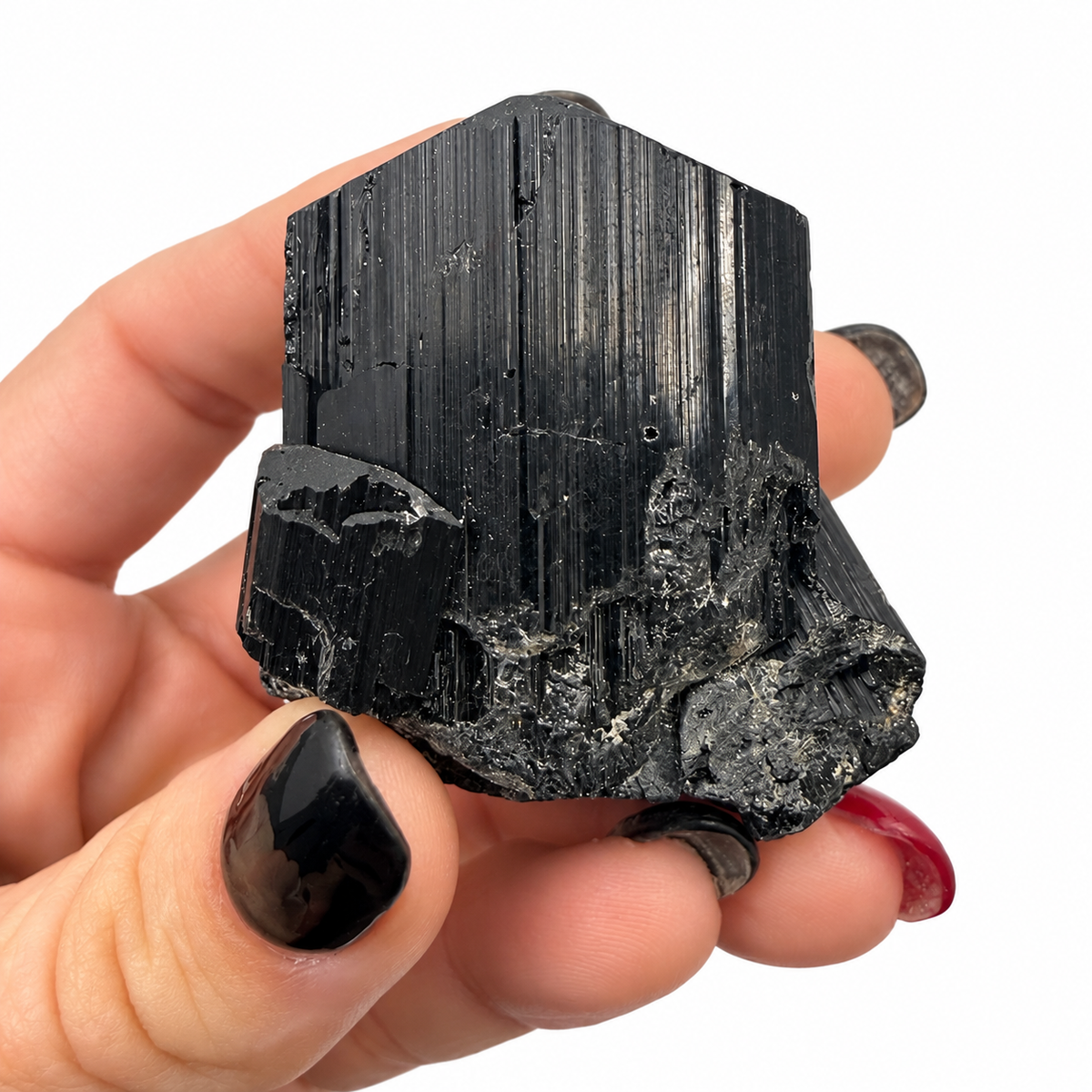 Intergrown black tourmaline crystals with deep striations, shown in hand - Magick Souls