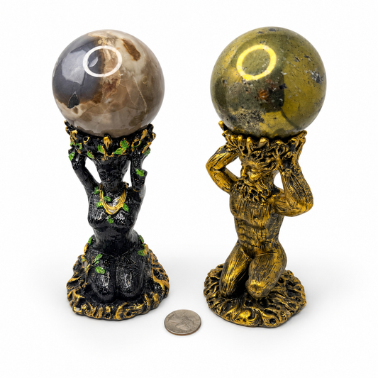 Pyrite sphere on gold God statue stand and volcano agate sphere on black Goddess statue stand, quarter for scale